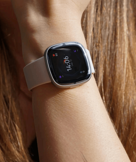 Smartwatch amb corretja grisa, al canell d’una dona.
