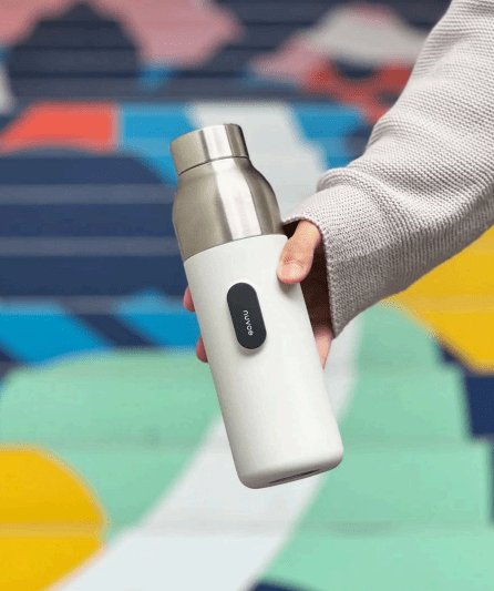 Ampolla purifica l'aigua, platejada amb la part inferior blanca a les mans d’una persona amb dessuadora gris.